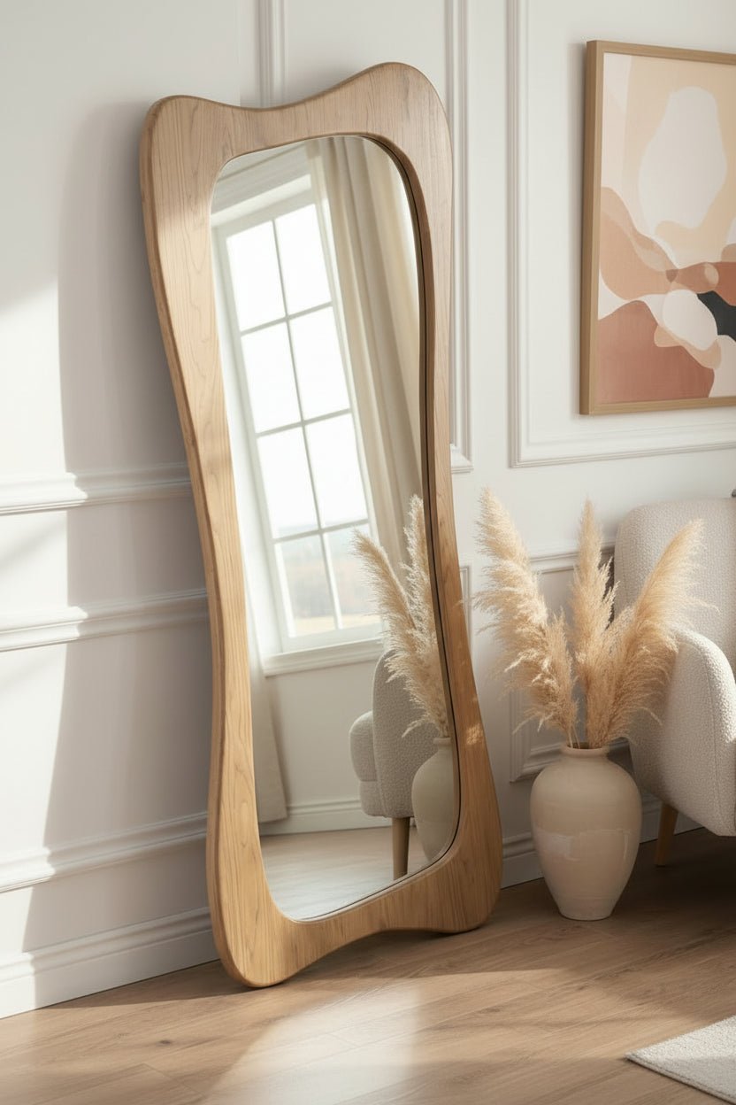 Wooden floor mirror leaning against a wall next to a sofa.