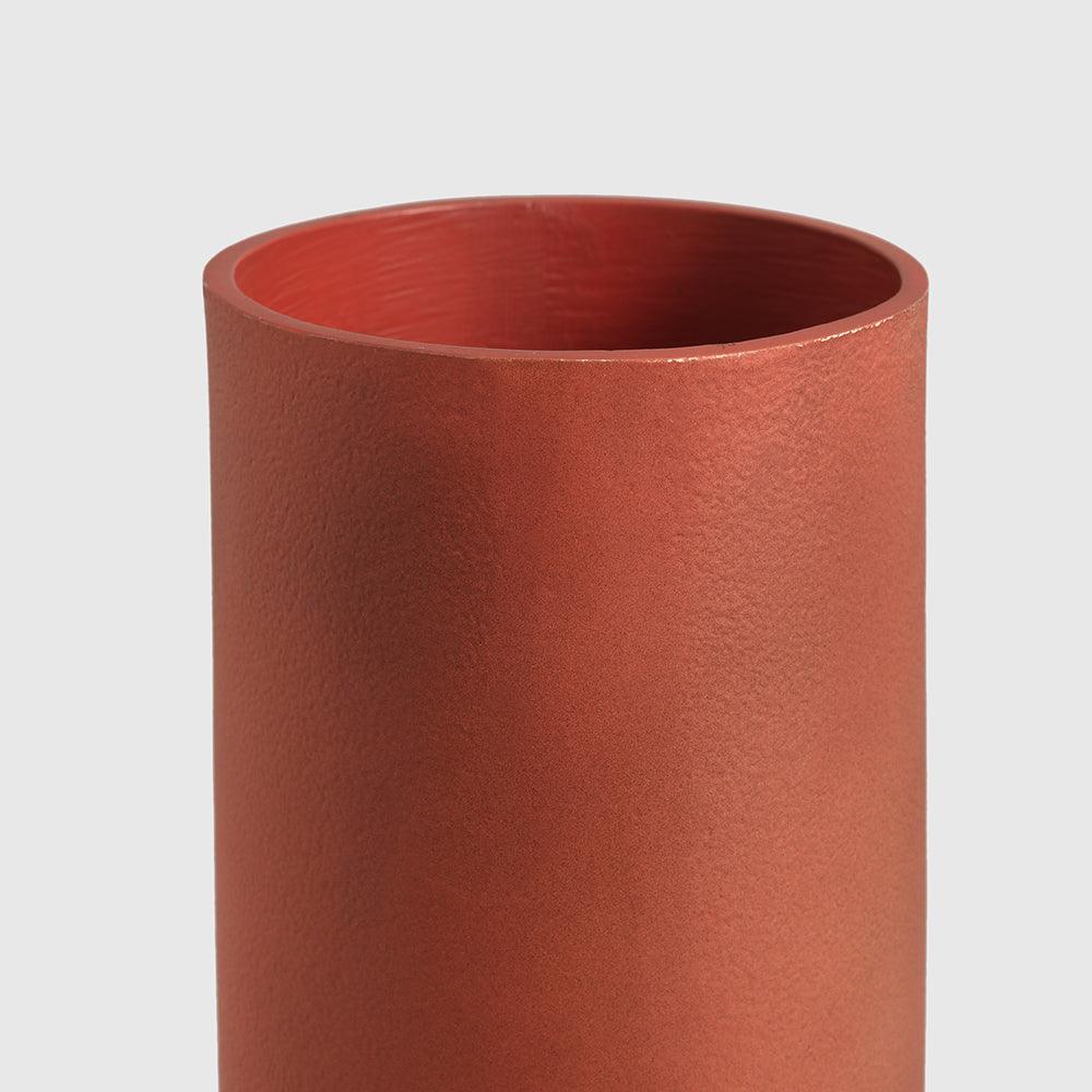 olored cylindrical vase on a light gray background