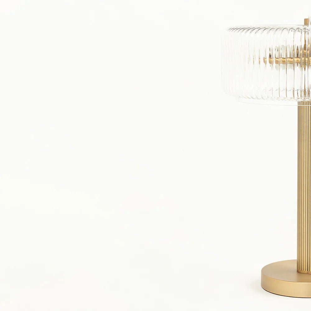 Gold table lamp with decorative design on a white background