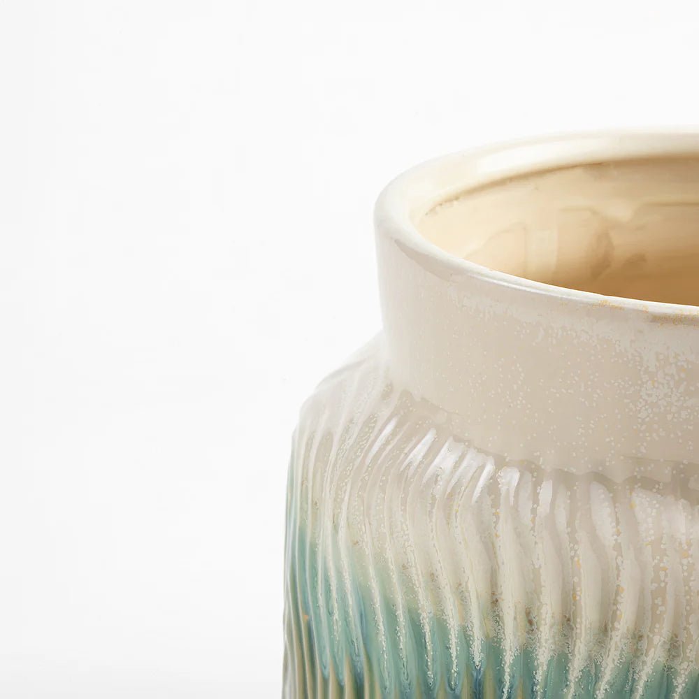 Close-up of a ceramic vase with a gradient design on a white background