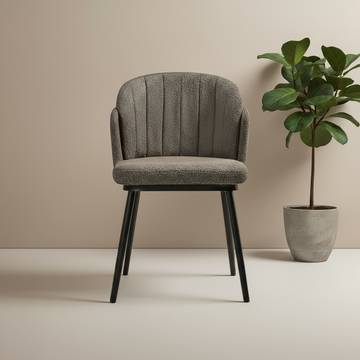 Gray upholstered chair with black legs next to a potted plant on a beige background
