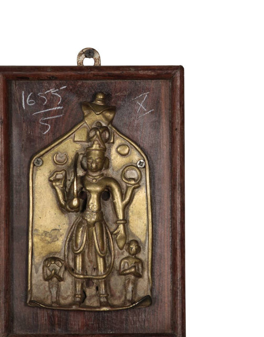 Handcrafted brass decorative wall panel featuring a traditional deity motif mounted on a rustic wooden frame with antique detailing.