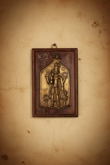 Handcrafted brass decorative wall panel featuring a traditional deity motif mounted on a rustic wooden frame with antique detailing.
