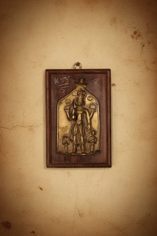 Handcrafted brass decorative wall panel featuring a traditional deity motif mounted on a rustic wooden frame with antique detailing.