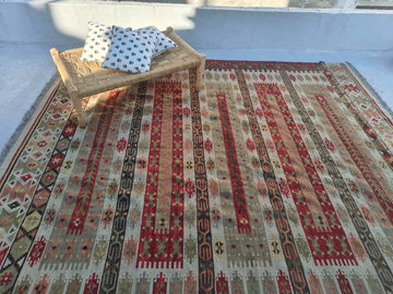 Patterned rug with a wooden bench and cushions on a light blue floor.