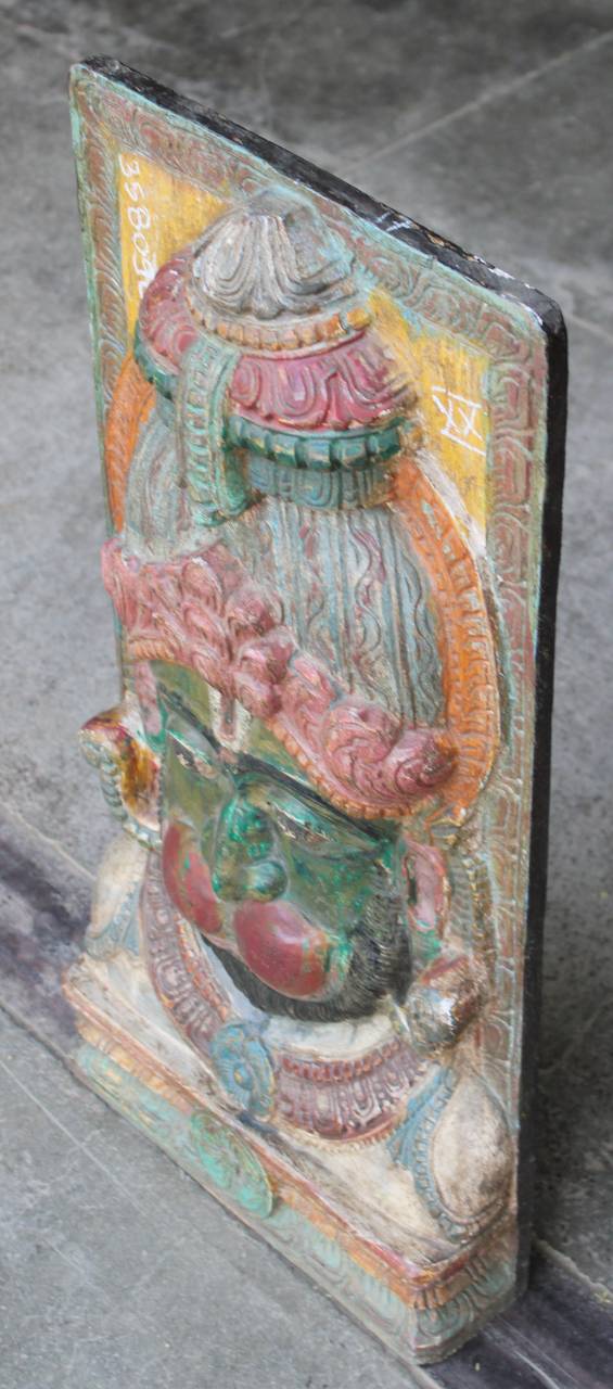 Decorative stone sculpture with colorful elements on a gray surface