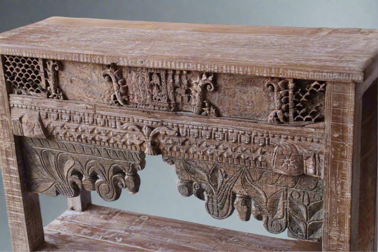 Wooden console table with intricate carvings on a plain background