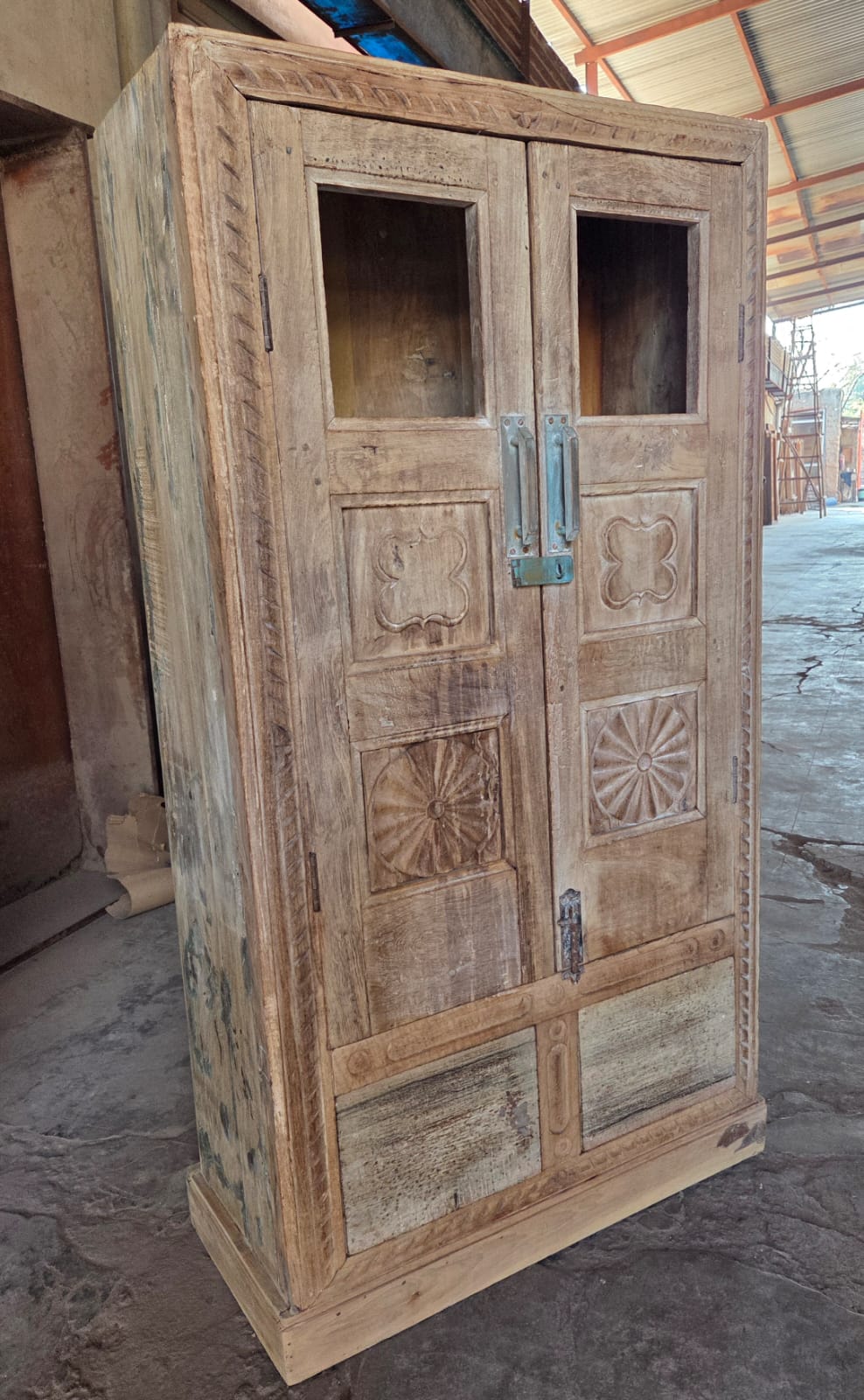 Wooden wardrobe with decorative carvings in a workshop setting