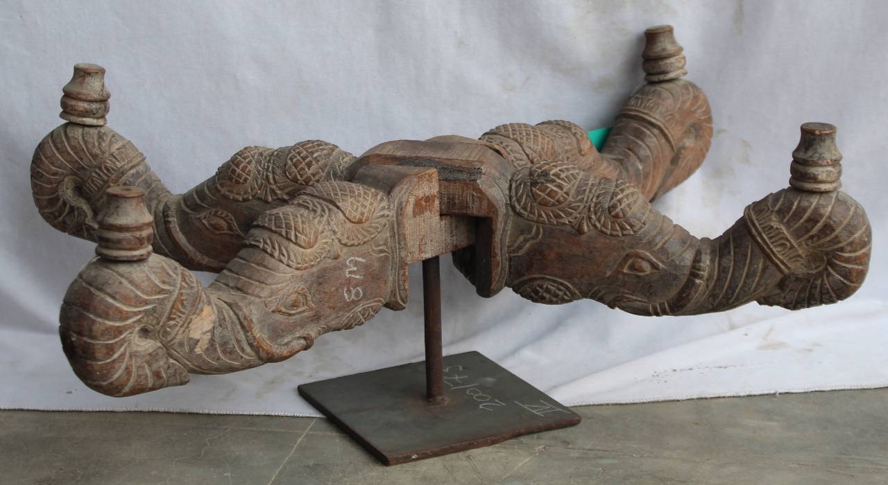 Decorative wooden sculpture on a stand against a white background