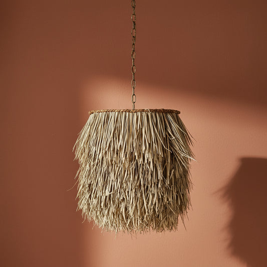 Rattan pendant light hanging against a brown background