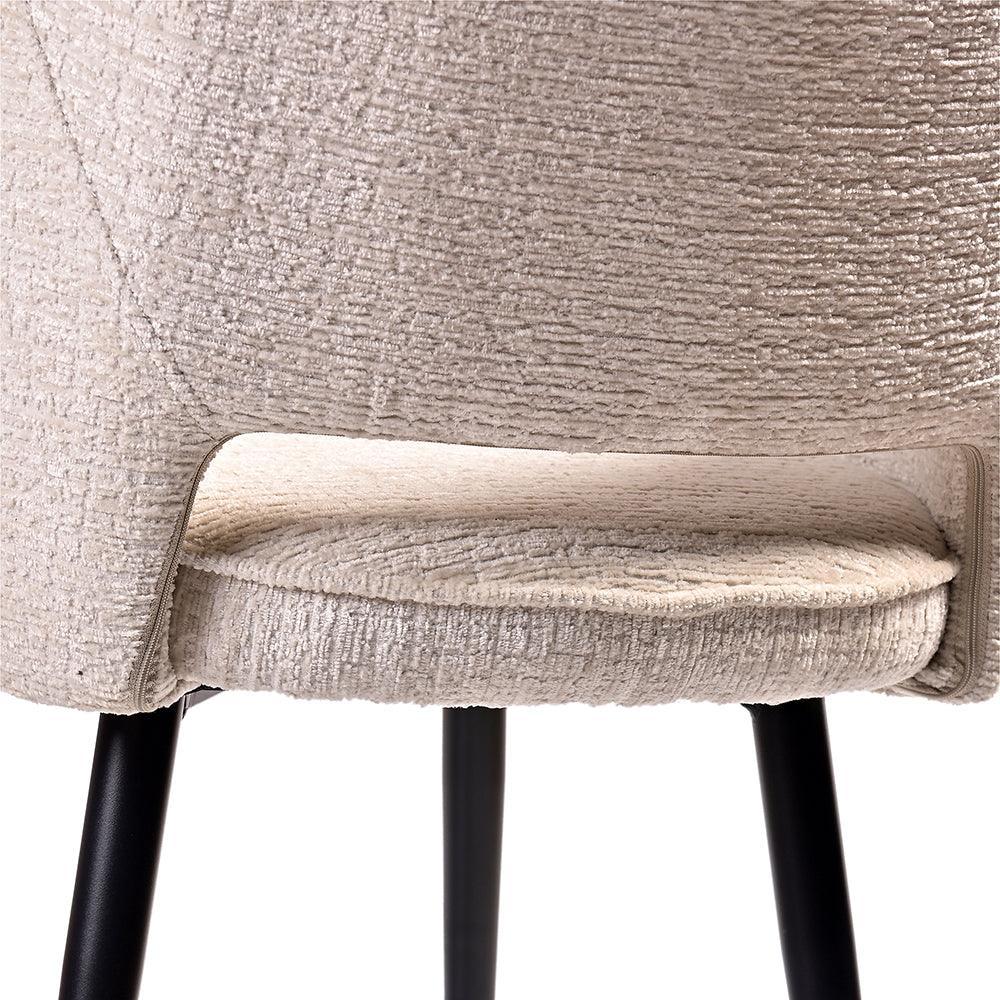 Close-up of a beige upholstered chair with black legs on a white background