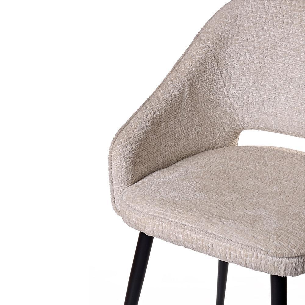 Close-up of a beige upholstered chair with black metal legs on a white background