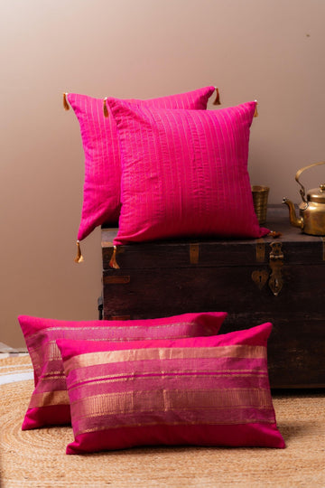 Two pink cushions on a wooden chest against a beige wall