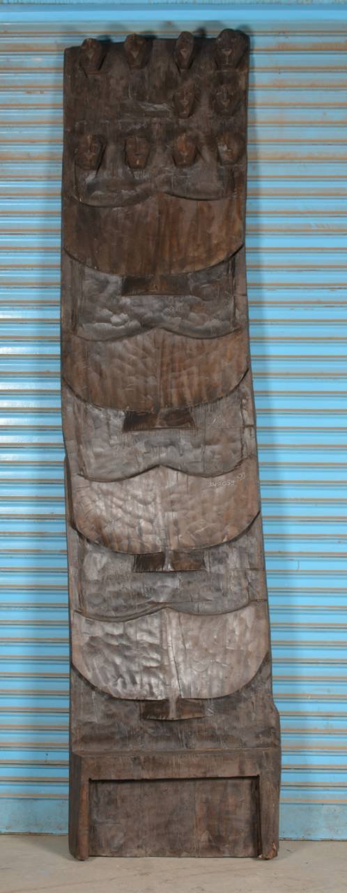 Wooden panel with carvings against a blue striped background