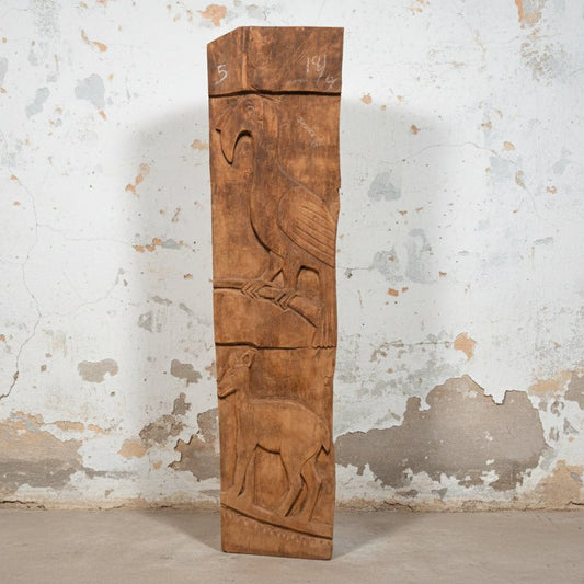 Wooden panel with carvings of a bird and deer on a plain background