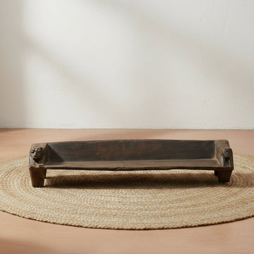 Wooden bench on a gray floor with a white wall background