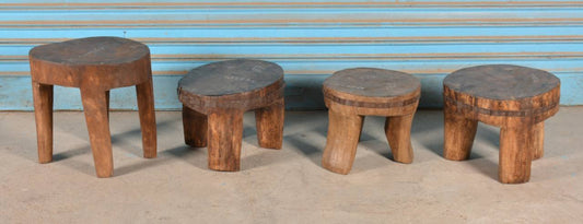 Set of five wooden stools with a blue wall in the background