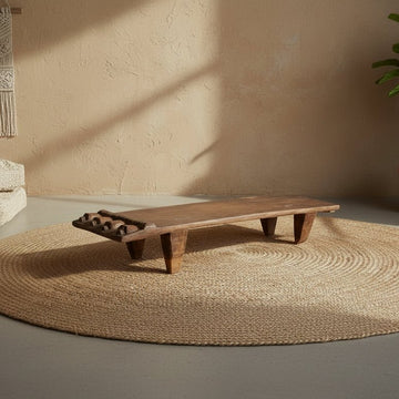 Wooden bench on a textured rug with a neutral wall background