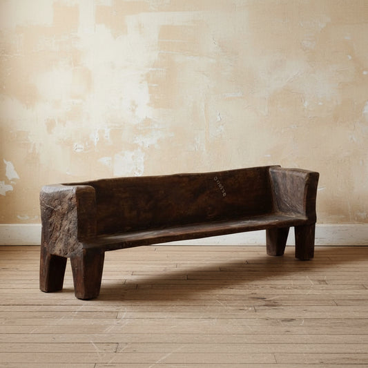 Wooden bench in a minimalistic room with light-colored floor and walls