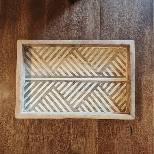 Wooden tray with geometric pattern on a wooden surface