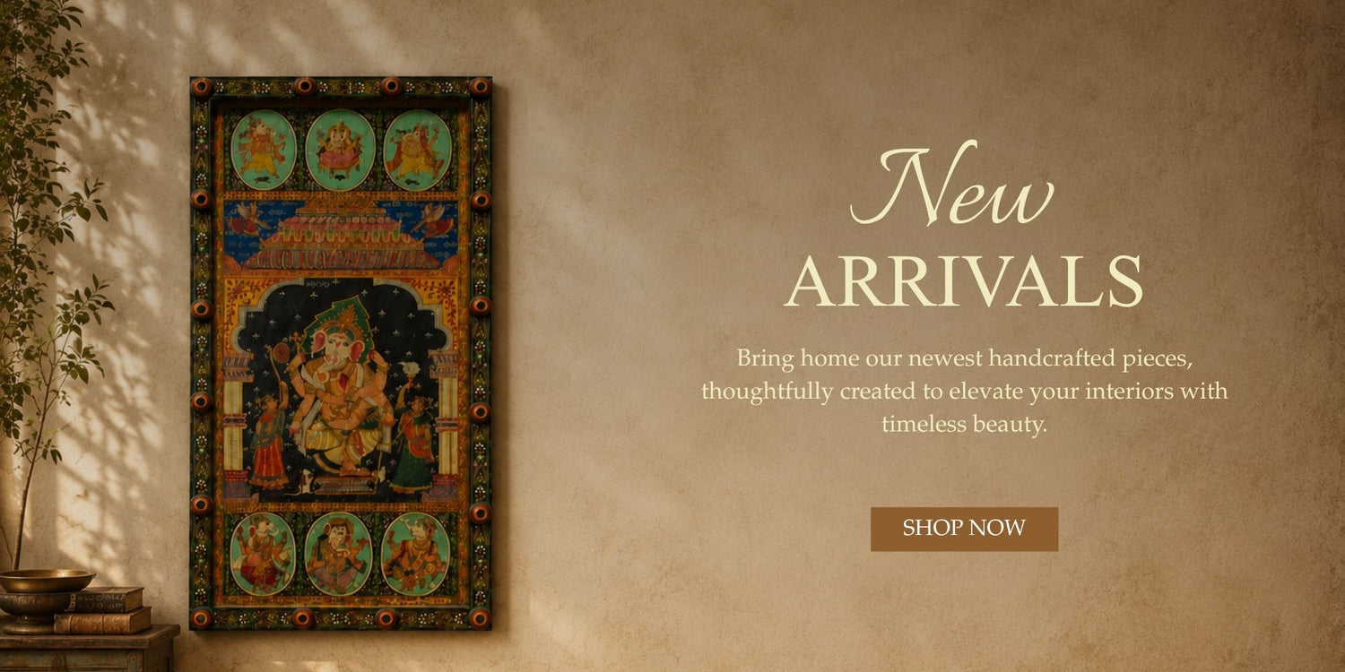 A decorative framed wall art piece with an ornate traditional illustration hangs on a warm beige textured wall beside a plant.