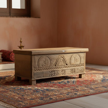 Wooden chest with intricate carvings on a patterned rug