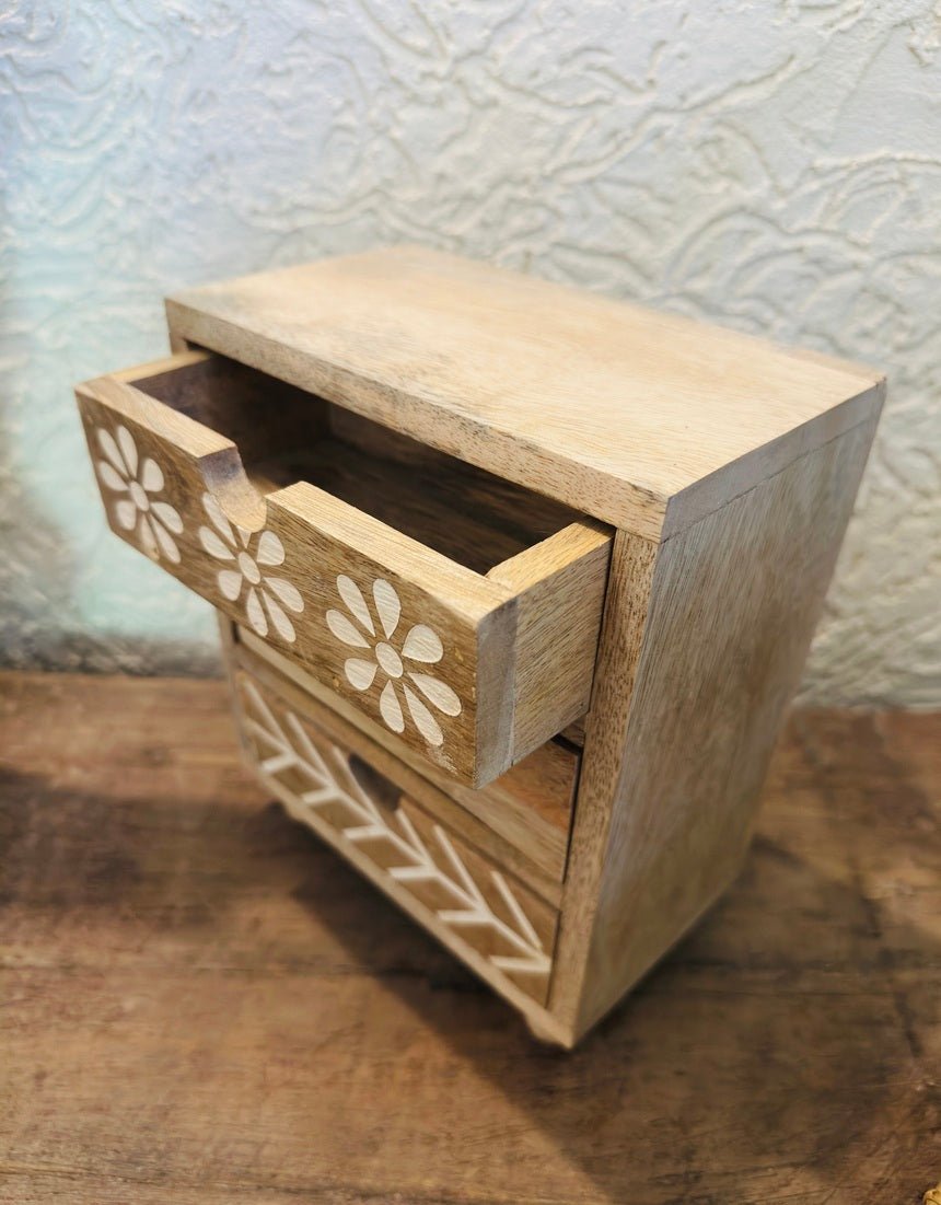 Wooden drawer with floral patterns on a wooden surface