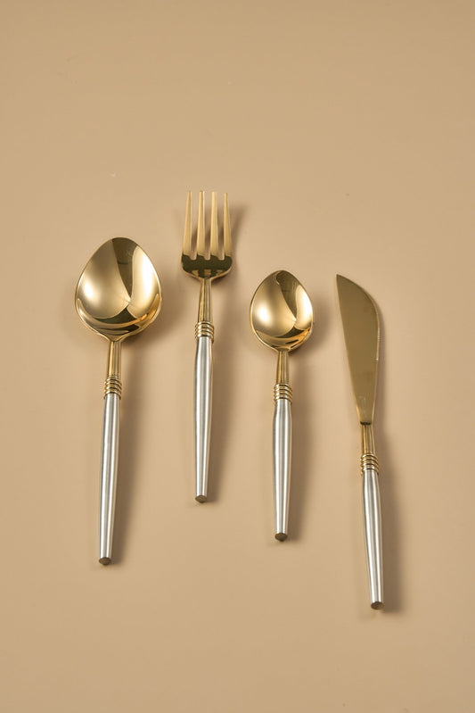 Set of gold and silver cutlery on a beige background