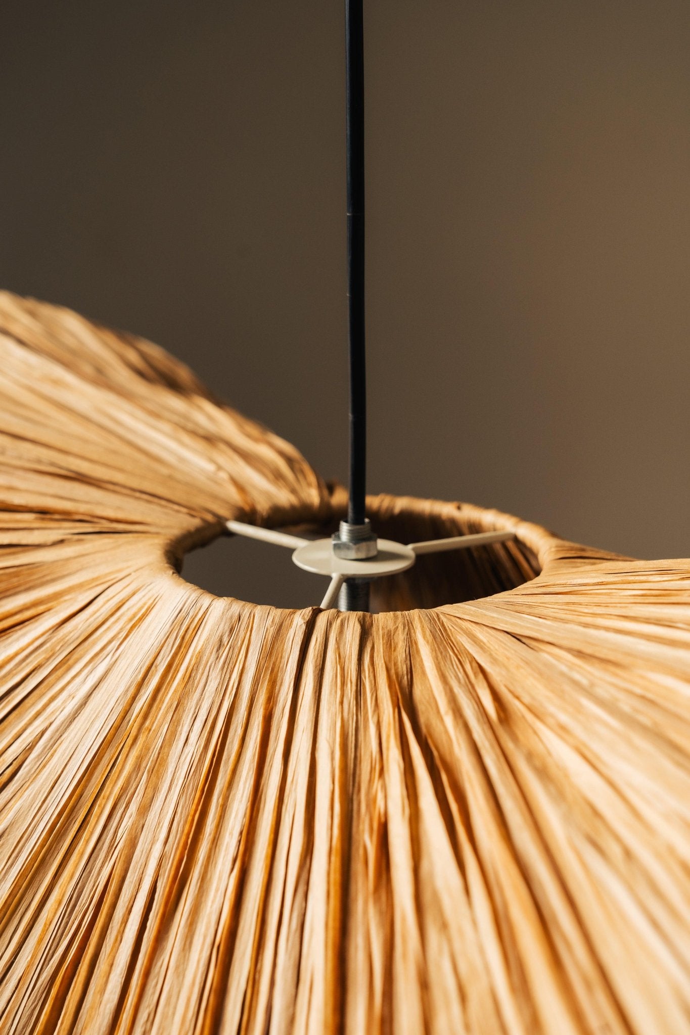 Close-up of a textured pendant light with a neutral background