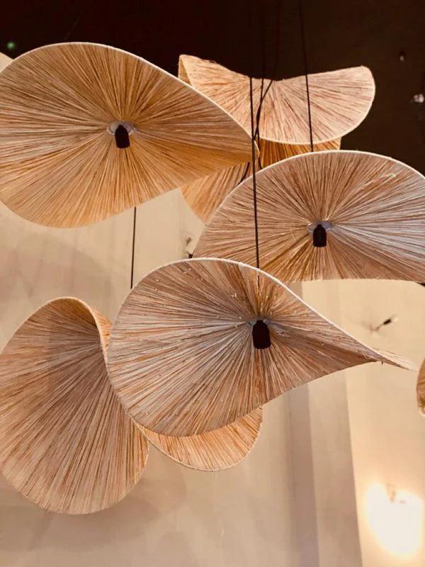 Decorative pendant lights with fan-like design hanging against a neutral background