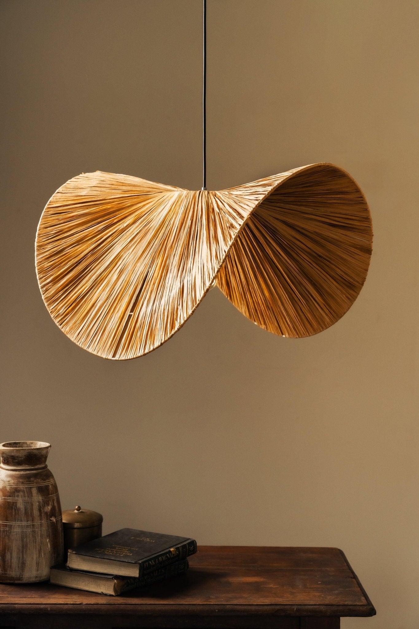Decorative pendant light with natural wood finish hanging against a neutral wall.
