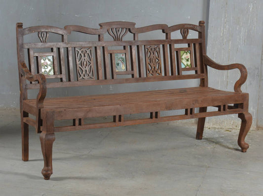 Wooden bench with intricate carvings on a plain background