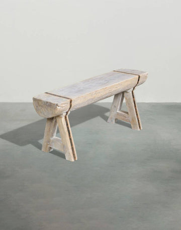 Wooden bench with a concrete seat on a gray floor
