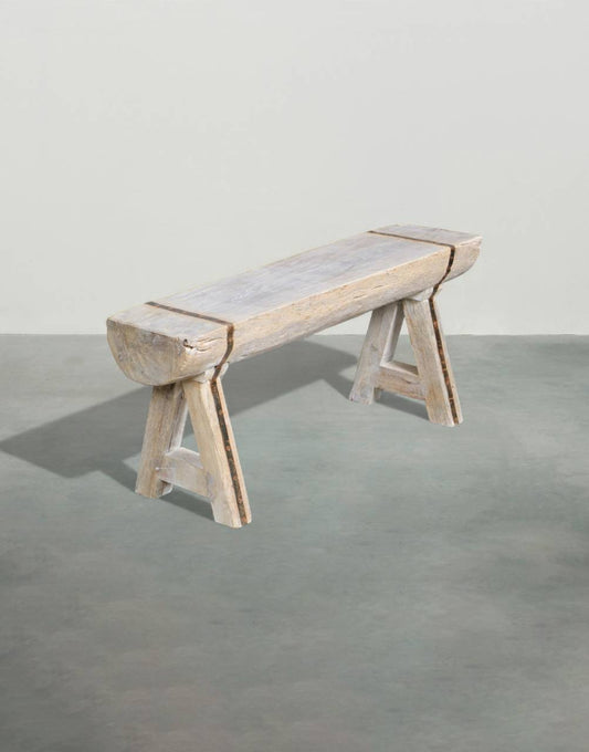Wooden bench with a concrete seat on a gray floor