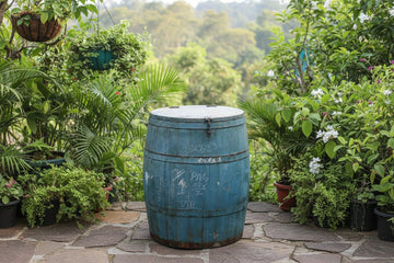 Rustic blue wooden barrel with visible wear and graffiti on a plain background