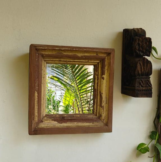 Wooden framed mirror on a wall with a view of greenery