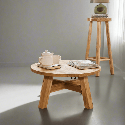 Wooden coffee table with a teapot and books on a plain background