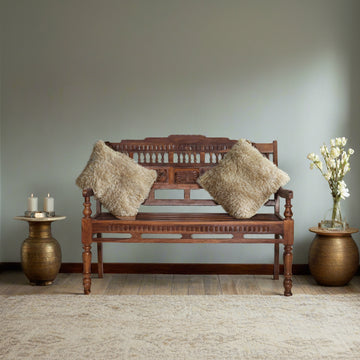 Wooden bench with decorative pillows in a room with a neutral color scheme