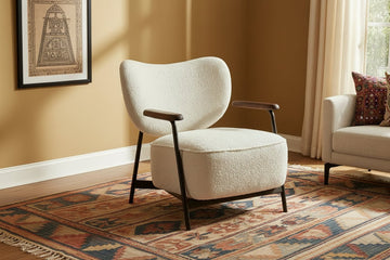 Modern armchair with wooden arms in a room with a window and marble table.