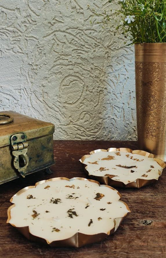 Decorative ceramic plates on a wooden surface with a textured wall and plant in the background