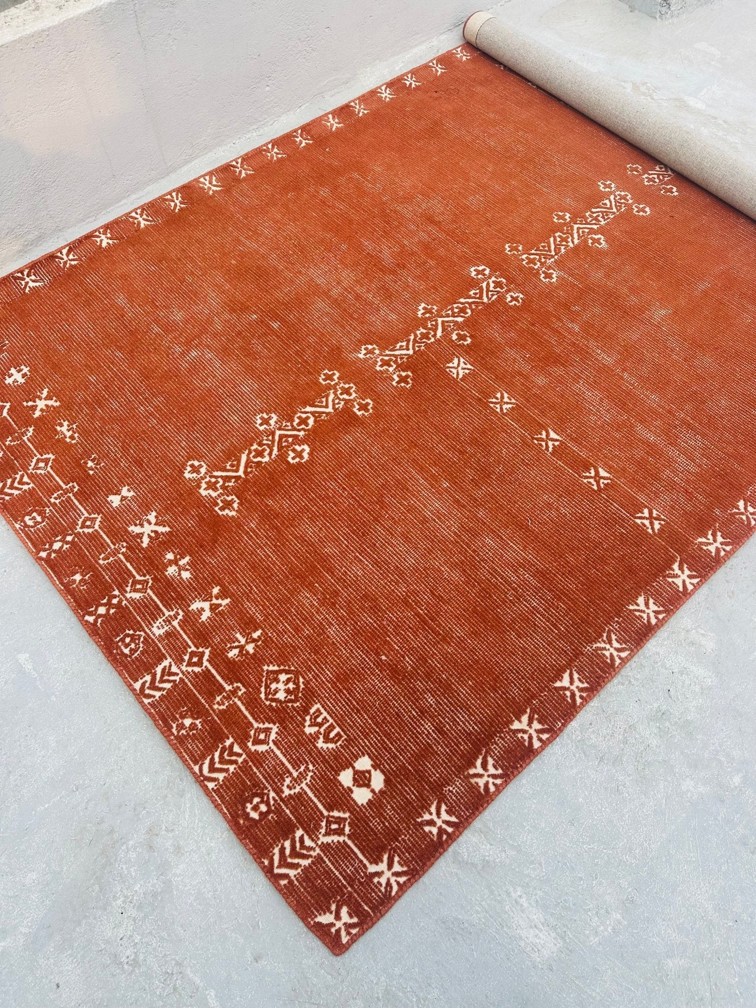 Brown rug with white patterns on a light gray floor