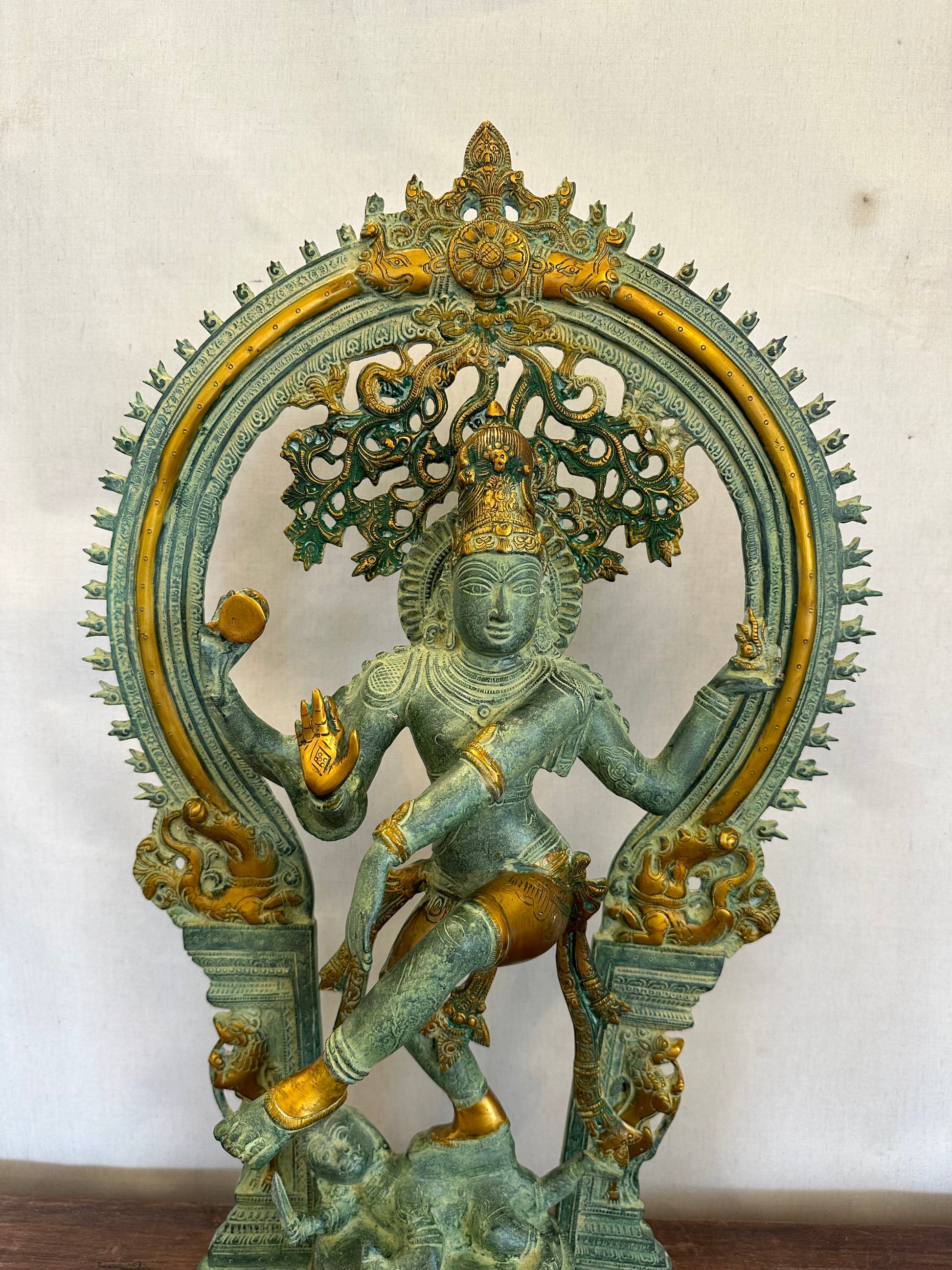 Decorative wall piece with a figure and intricate designs on a plain background