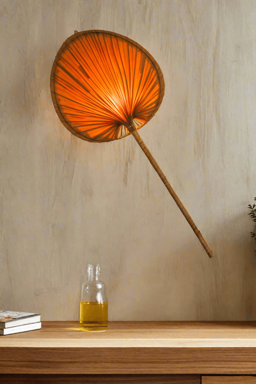 A wall-mounted palm leaf lampshade emitting a warm glow, installed above a table in a dimly lit room.