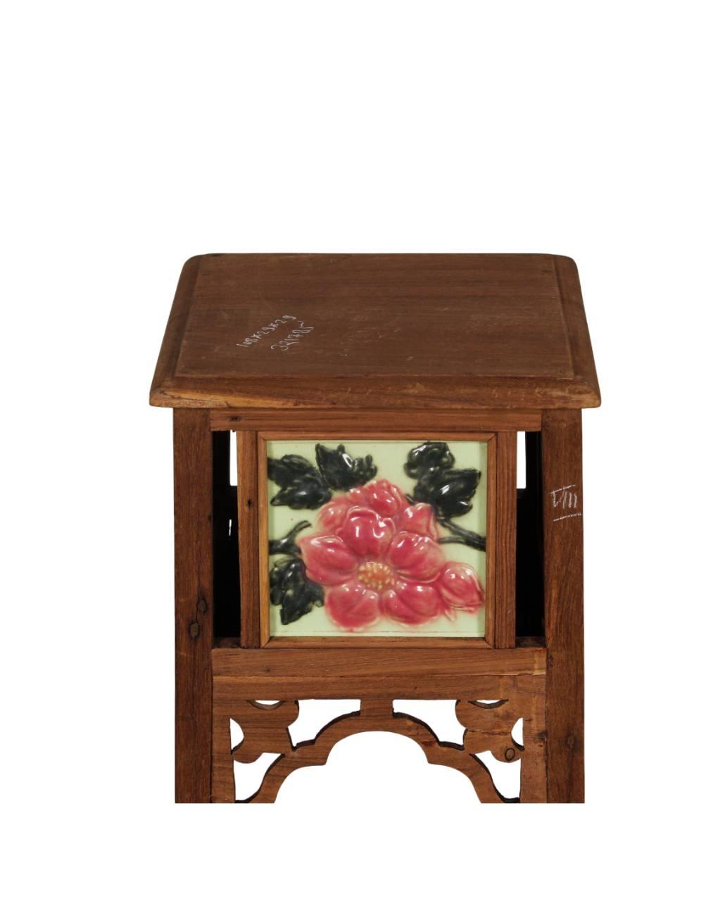 Wooden side table with floral tile design on a white background
