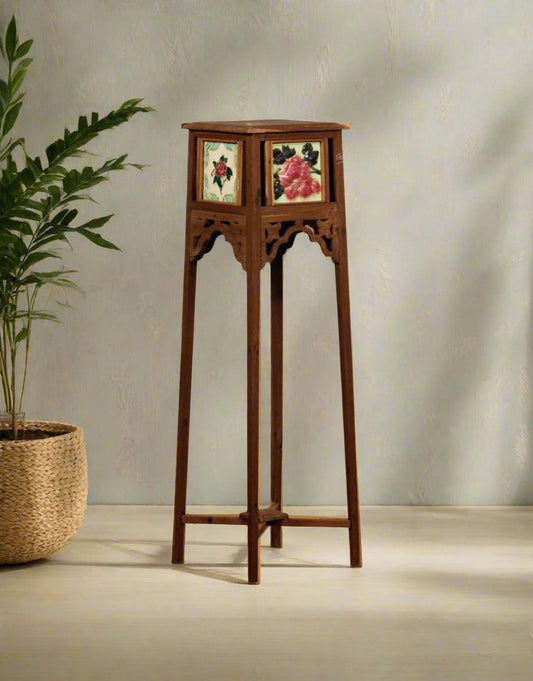 Wooden plant stand with decorative panels against a plain wall