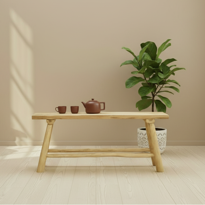 Wooden table with tea set and plant against a beige wall