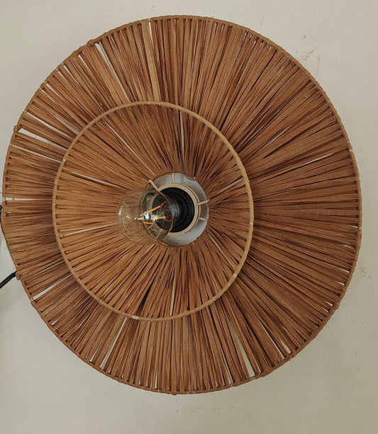 Decorative wall light fixture with woven design on a plain wall.