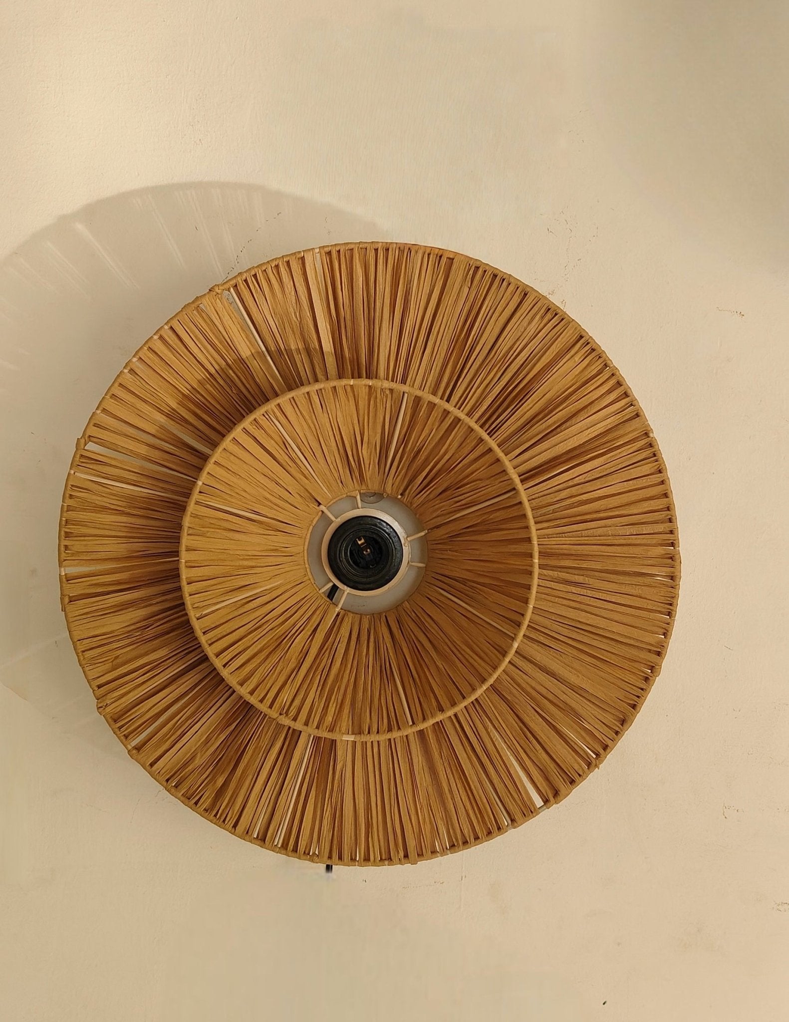 Ceiling light fixture with woven design on a beige wall