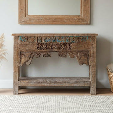 Wooden console table with intricate carvings in a room setting