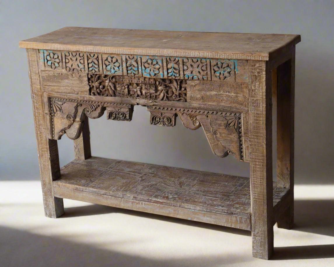 Wooden console table with intricate carvings on a plain background